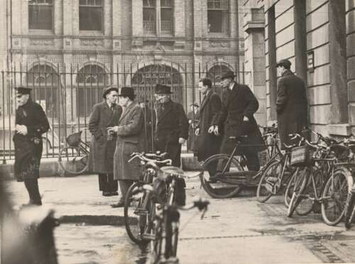 Harry White emerging from a preliminary court hearing at Chancery Place in October 1946, handcuffed and accompanied by eight armed ‘Branch men’.